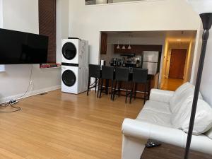 uma sala de estar com um sofá branco e uma televisão em Full loft apartment near Omni Hotel em New Haven