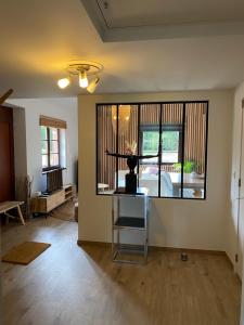 a living room with a person standing on a table at Le logis des Chênes, superbe bungalow dans quartier résidentiel proche de Namur in Wépion