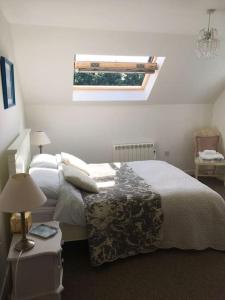 a bedroom with a bed and a skylight at Wonderful rural dwelling- relax or explore Kent! in Kent