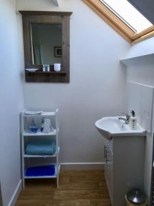 a bathroom with a sink and a mirror on the wall at Wonderful rural dwelling- relax or explore Kent! in Kent