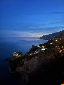 an island in the middle of the water at night at Holiday House Piccirillo in Vietri sul Mare
