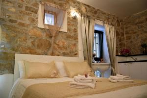 a bedroom with a bed with towels on it at Apartments Bepina in Split