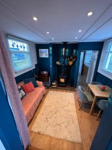 1 dormitorio con paredes azules, 1 cama y 1 mesa en Toosey Lass - St Osyth creek en Saint Osyth