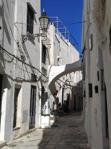 an alley with white buildings and a street light at Nel Vico Antico in Ostuni