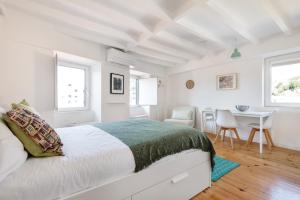 ポルトにあるCasa Floraの白いベッドルーム(ベッド1台、テーブル付)