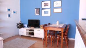 a dining room with a table and a tv at ESPAÇO AZUL Original in Curitiba