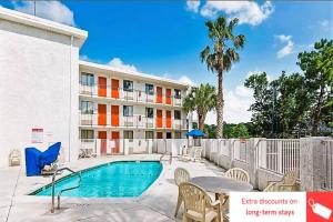 a hotel with a swimming pool and a building at OYO Hotel Mobile, AL I-65 at Airport Blvd in Mobile