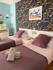 ベナルマデナにあるAgataのベッド2台が備わる客室で、壁には絵画が飾られています。