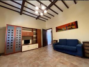 uma sala de estar com um sofá azul e uma televisão em Appartamento La sosta em San Romano