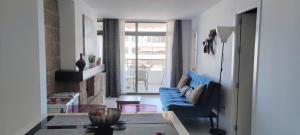 ein Wohnzimmer mit einem blauen Sofa und einem Fenster in der Unterkunft Happy Nogalera Centro - Vistas al Mar in Torremolinos