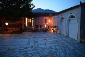 un patio de piedra frente a una casa por la noche en Βίλα Εύη, en Ligourio