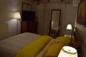a bedroom with a yellow bed and a television at Βίλα Εύη in Lygourio