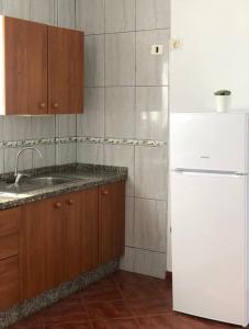 a kitchen with a white refrigerator and a sink at CASA CORALES in La Mareta