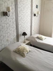 ジョンザックにあるRésidence du Châteauのベッドルーム1室(ベッド2台、テーブルの上にランプ付)