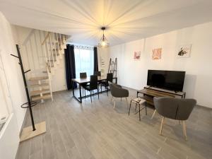 Le Gond-Pontouvreにある178C - Duplex T2 Tout Confort du Gond - 60 m2のリビングルーム(テレビ、テーブル、椅子付)