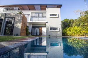 a house with a swimming pool in front of it at Panther Bay Boutique Hotel in Akumal