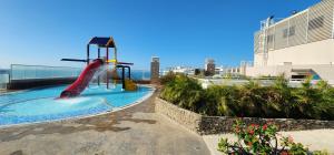 a playground with a slide in a swimming pool at Apartamento frente al mar en Reserva del Mar apto 1829 in Gaira