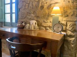 a table with a clock and a lamp on it at Habitaciones rurales en Colomers in Colomés