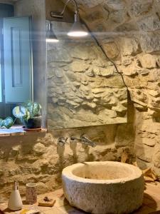 a stone bathroom with a sink and a stone wall at Habitaciones rurales en Colomers in Colomés