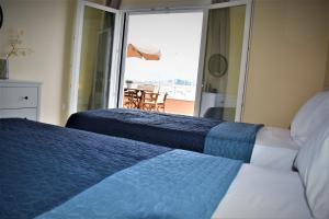 two beds in a bedroom with a view of the ocean at Christina's apartment 2 in Kontokali