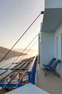 balcón con bancos y vistas al océano en Skorponeria Bay Luxury Villas, en Skroponeria