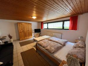 a bedroom with two beds and a large window at Pension Ernst im Herzen des Pfälzerwaldes mit Küche in Elmstein
