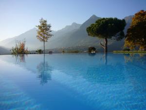 uma grande piscina de água azul com árvores e montanhas em Taushof em Scena