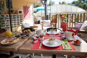 a wooden table with breakfast food on a patio at Les Chalets du Périgord in Sarlat-la-Canéda