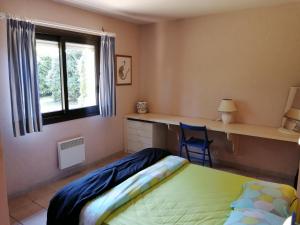 een slaapkamer met een bed, een bureau en een raam bij Landes OCEANES - Chambres privées dans villa avec jardin in Lit-et-Mixe