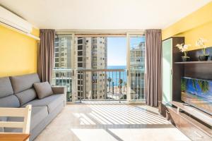 sala de estar con sofá y ventana grande en Carabelas II 6-2, en Benidorm