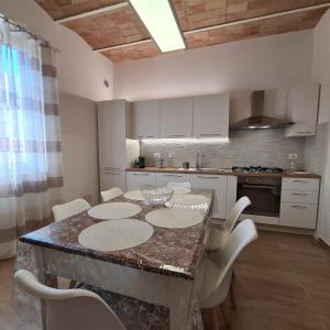 a kitchen with a table with chairs and a counter top at Nel cuore di Santa Maria degli Angeli in Santa Maria degli Angeli