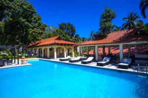 a swimming pool with chairs and a gazebo at Auberge Villa Cana in Cap-Haïtien