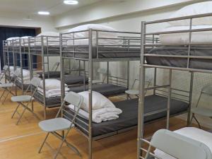 a group of bunk beds in a room with chairs at Bakkegata - Blue House Dormitory in Odda