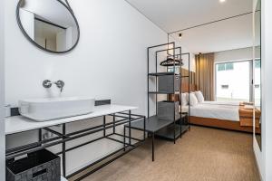 een badkamer met een wastafel en een spiegel bij Casa do Batente - By WeHost in Funchal