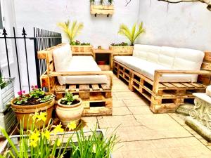 a patio with two benches and potted plants at Camelford House in Brighton & Hove