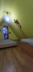 een groene kamer met 2 bedden en een licht bij Vikendica Pavle in Vrhpolje