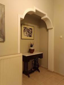 - un couloir avec une table et une plante en pot dans l'établissement Κεντρικό ευρύχωρο στούντιο με parking, à Larissa