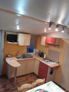 a small kitchen with a sink and a stove at location mobil-home in Saint-Chéron