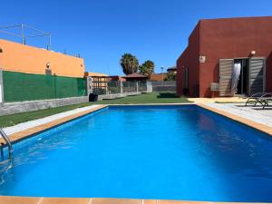 a large blue swimming pool next to a building at Villa Magna in Caleta De Fuste