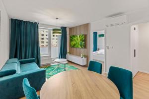 a living room with a blue couch and a table at LAM Green w AC & balcony in Bratislava