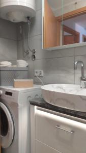 La salle de bains est pourvue d'un lavabo et d'un lave-linge. dans l'établissement APARTMANI "ZUKA", à Korčula