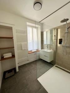 a large bathroom with a shower and a sink at Le Gite de la Poterne, maison en bordure du Serein in Chablis