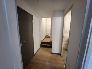 pusty korytarz z drzwiami i lustrem w obiekcie Spacieux 2 chambres, paisible w mieście Bar-le-Duc