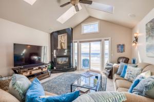 a living room with a couch and a tv at Seascape Rockaway - Meredith Lodging in Rockaway Beach