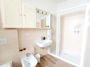 een witte badkamer met een wastafel en een douche bij la casa del barcaiolo in Malgrate