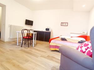een slaapkamer met een bed, een tafel en een bank bij la casa del barcaiolo in Malgrate