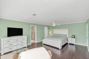 um quarto com uma cama e uma televisão de ecrã plano em Beauty on the Water! Lake House near the beaches! em Galveston