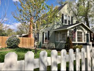 a white picket fence in front of a house at The Historic Blue Bird Cottage in Colorado Springs