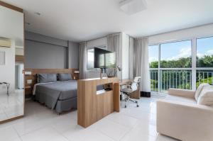 1 dormitorio con 1 cama y escritorio con TV en Flat Barra Da Tijuca, en Río de Janeiro