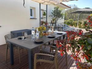 einen Tisch mit Stühlen und einem Sonnenschirm auf einer Terrasse in der Unterkunft Magnifique villa récente entre mer et montagne située entre Ajaccio et Porticcio in Cauro